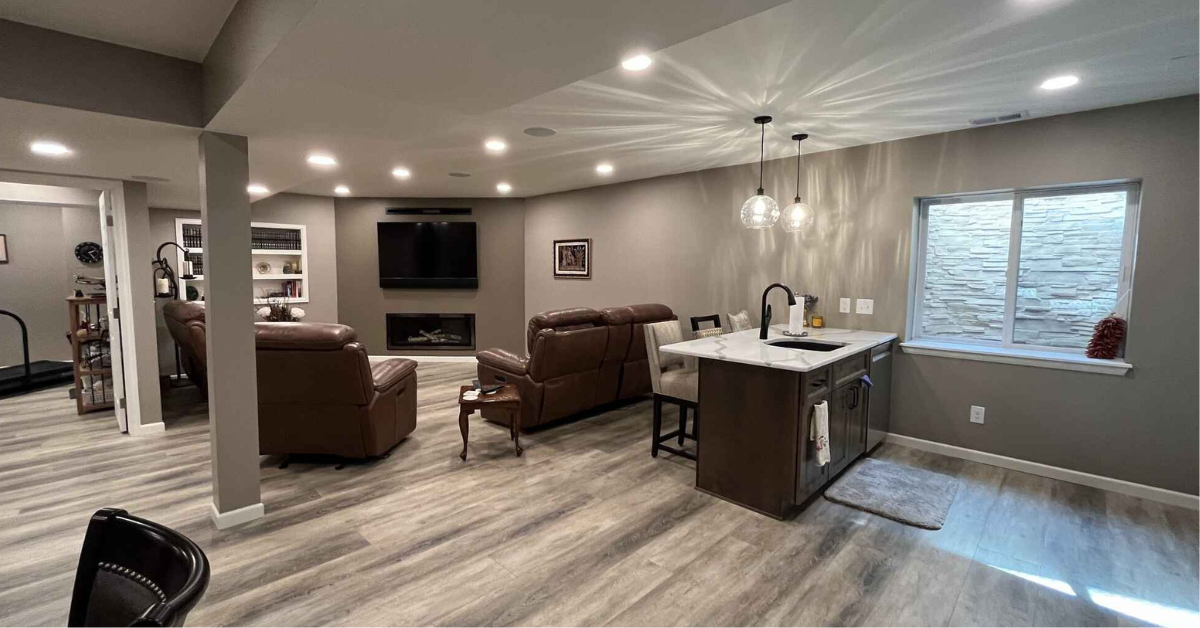 basement with light colored hard wood floors, canned lighting, and sink.